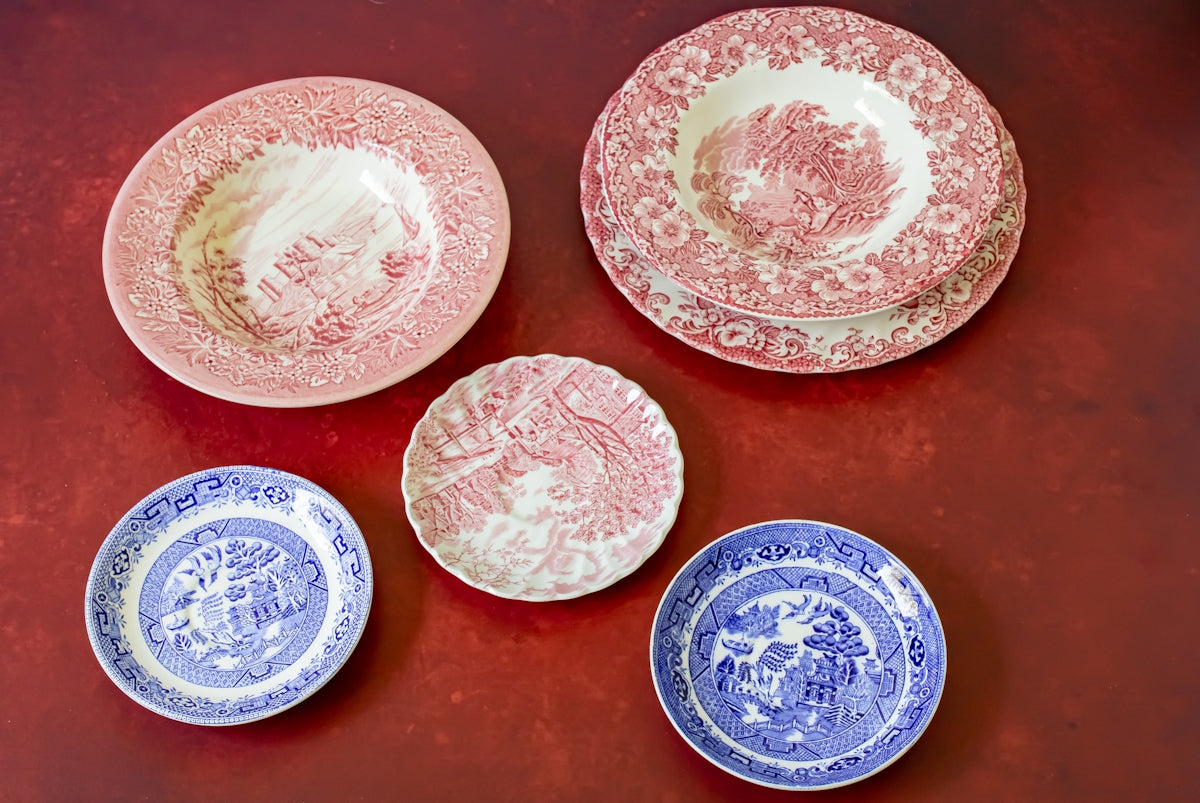 a group of four plates sitting on top of a red table
