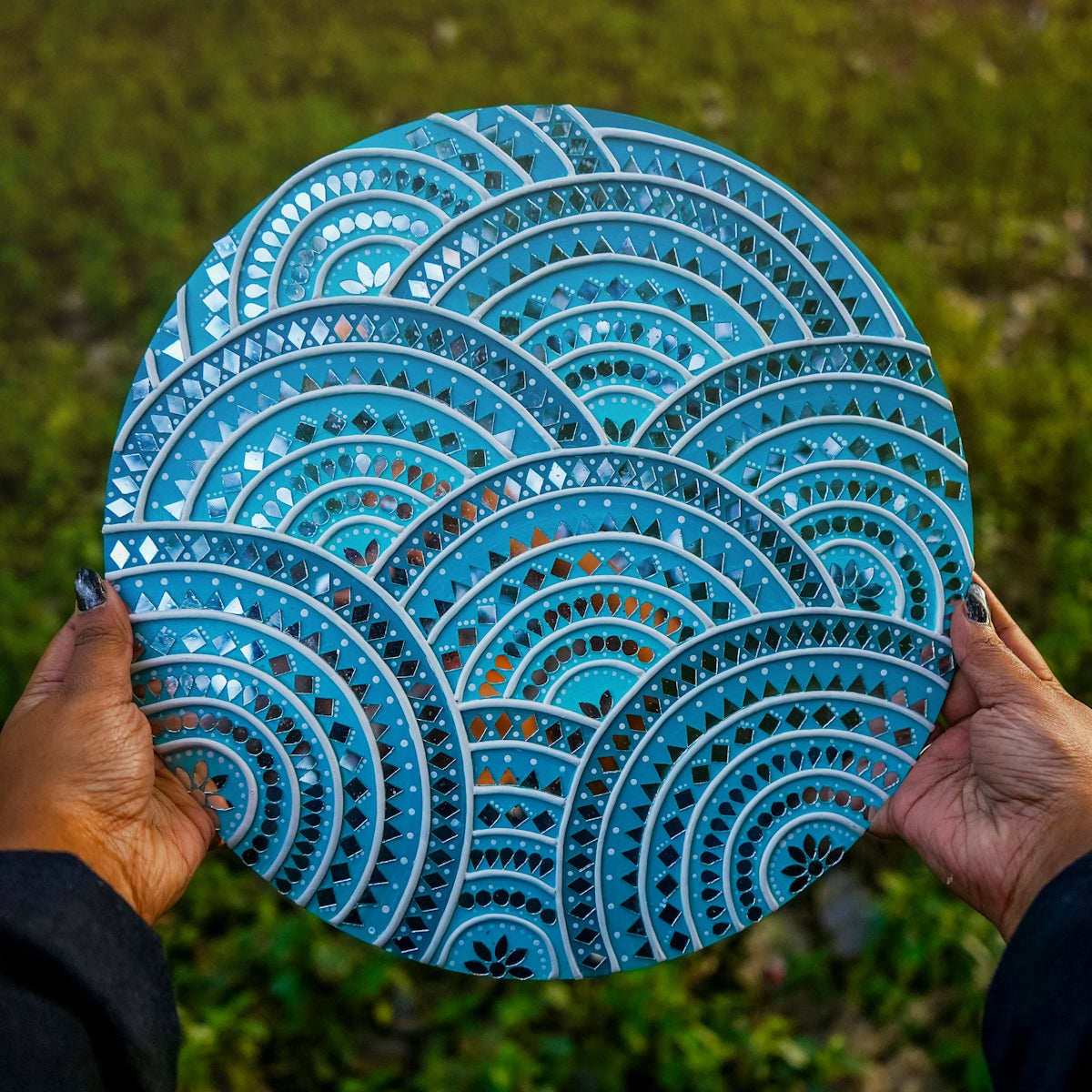 A person holding a plate with a blue design on it
