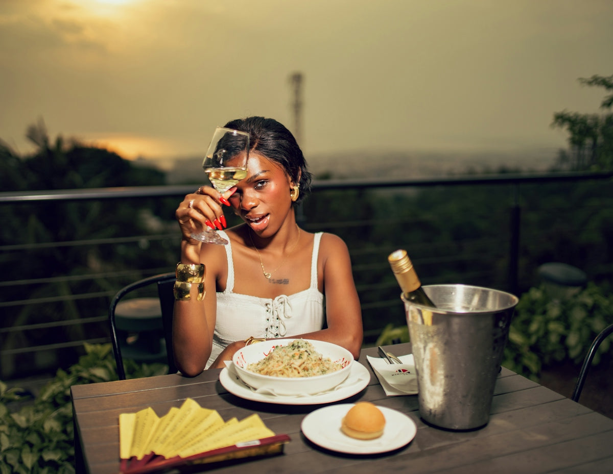 Woman holding wine glass at outdoor dinner table