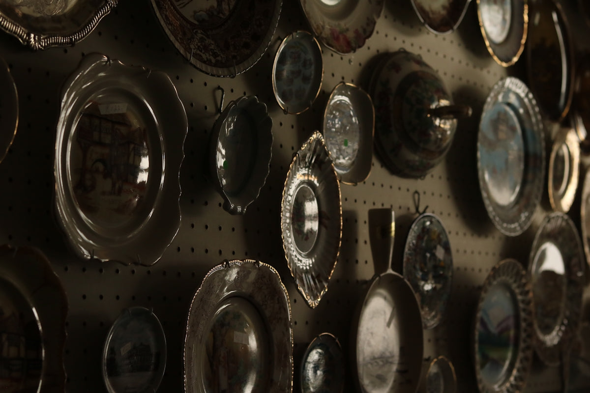 Collection of antique plates displayed on a wall.