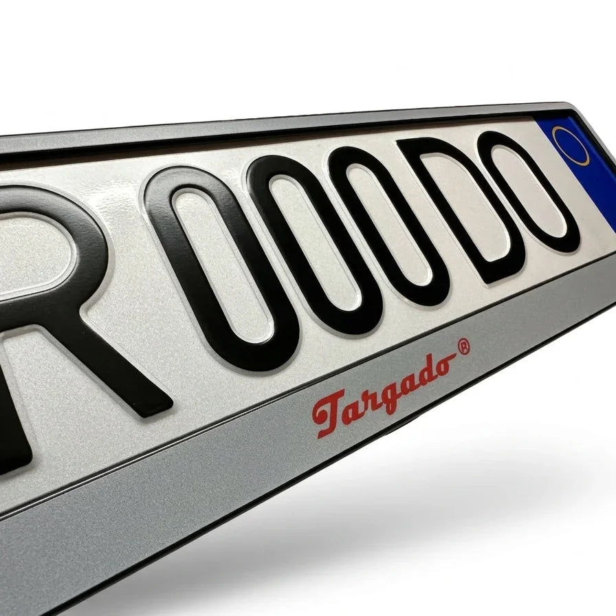Close-up of a silver Targado Srl license plate holder with red logo and black lettering.