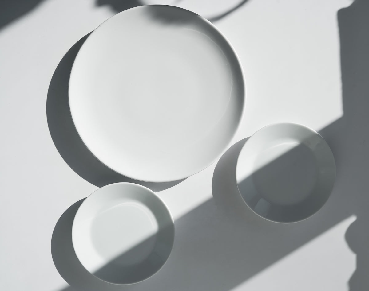 a white plate and two white bowls on a table