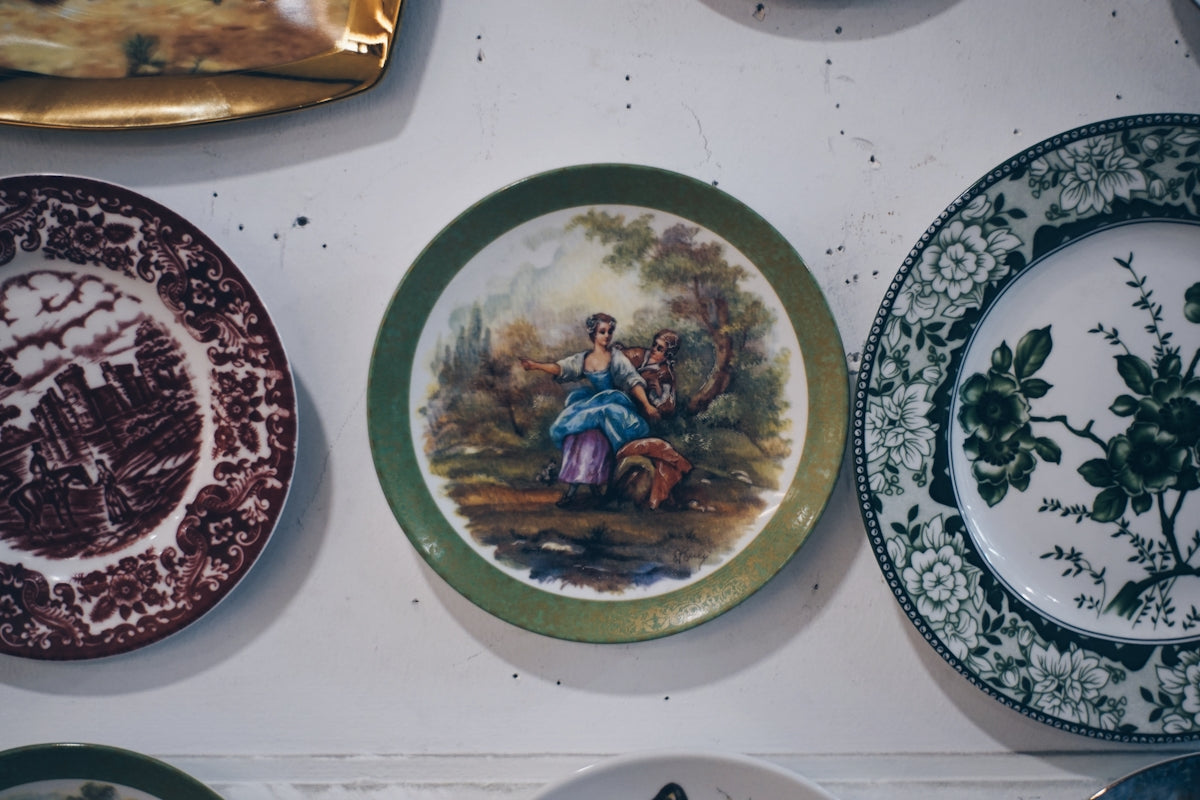 Collection of decorative plates with painted scenes.