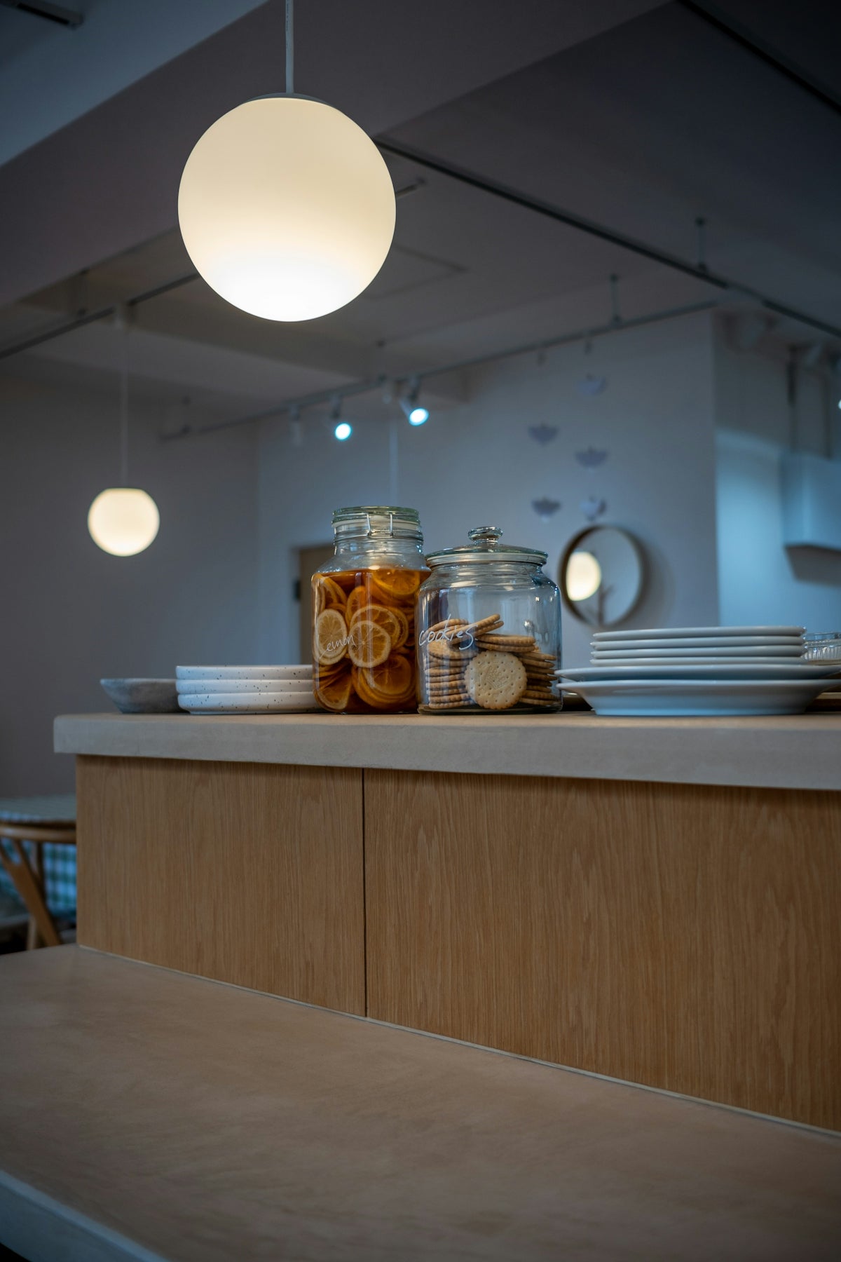 Two jars of snacks on a counter with plates.