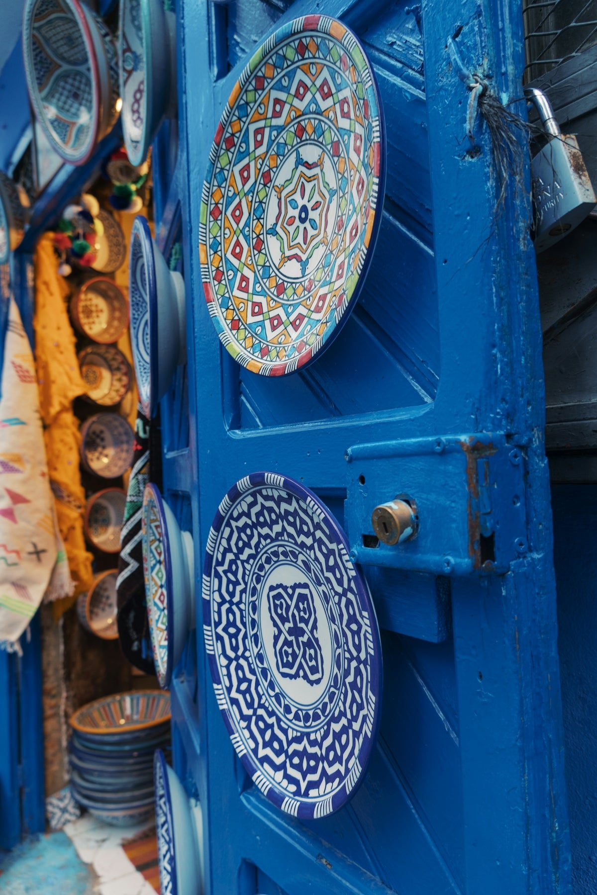 Colorful decorative plates displayed on a bright blue door.