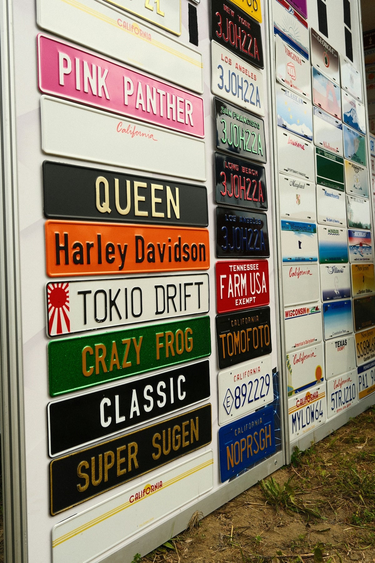 Personalized novelty license plates displayed on a white board.